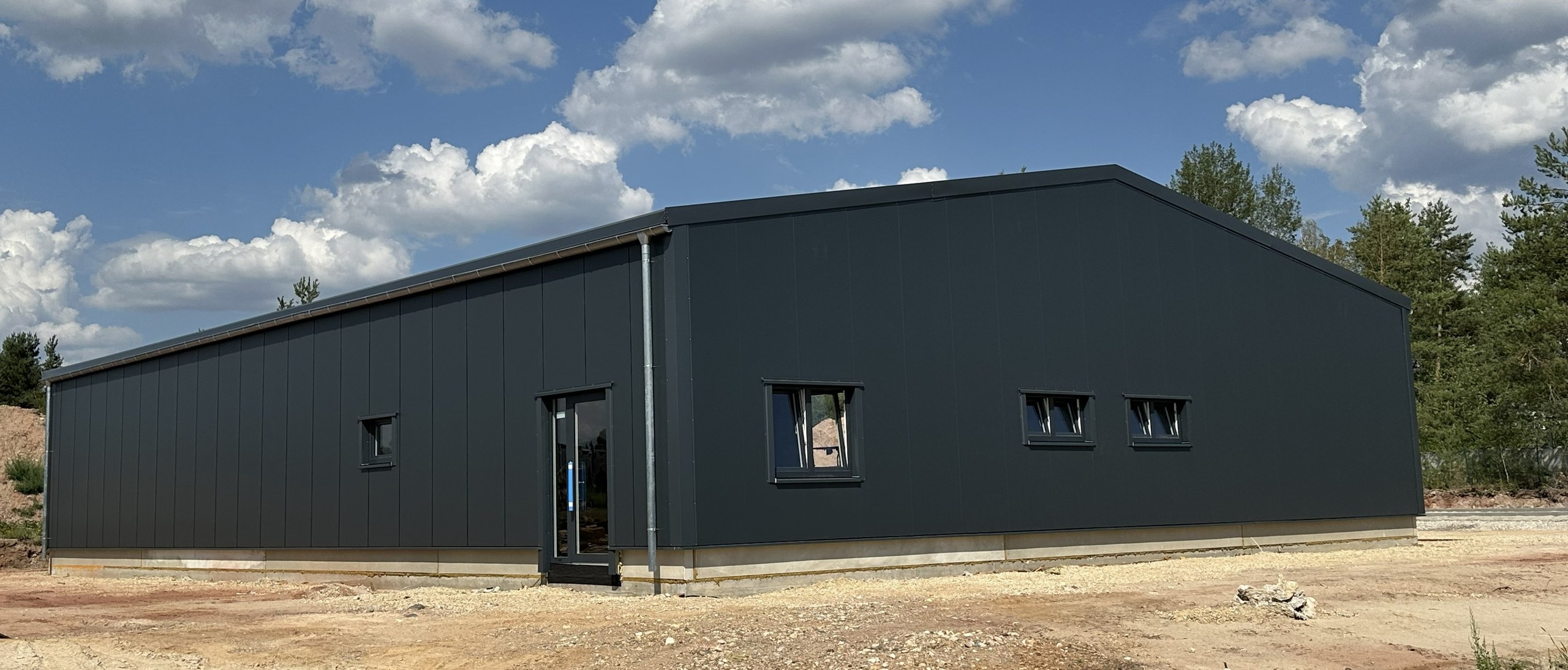 Fertiggestellte Stahl-Lagerhalle in Hütten bei Grafenwöhr mit anthrazitfarbener Fassade und Satteldach