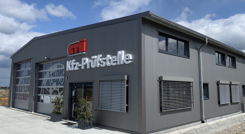 GTÜ Kfz-Prüfstelle in einer Stahlhalle mit Bürotrakt, Sektionaltoren und Raffstore-Verschattung