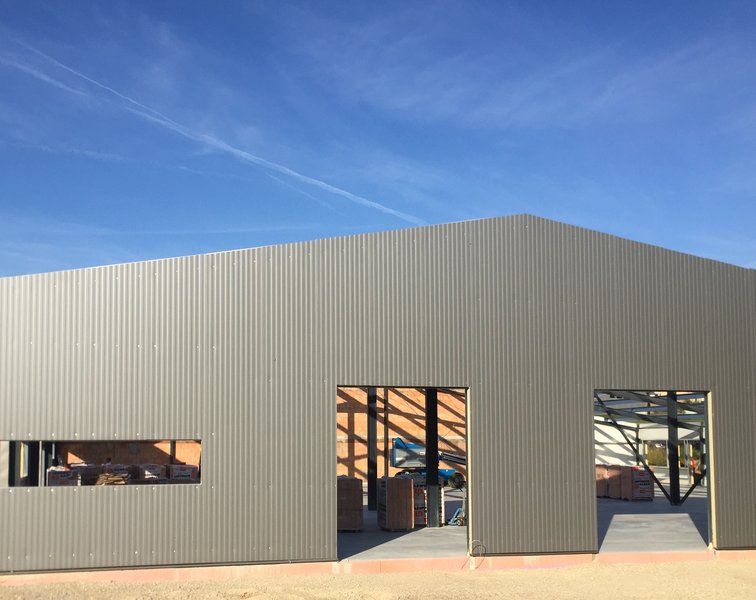 Vorgefertigte Sandwichelemente werden als Fassade auf die Stahlkonstruktion einer Halle montiert